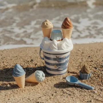 Otrok se igra z Little Dutch Ice Cream Ocean setom v mivki na plaži