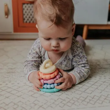 Dojenček se igra z Jellystone silikonsko natikanko Pastel za fino motoriko