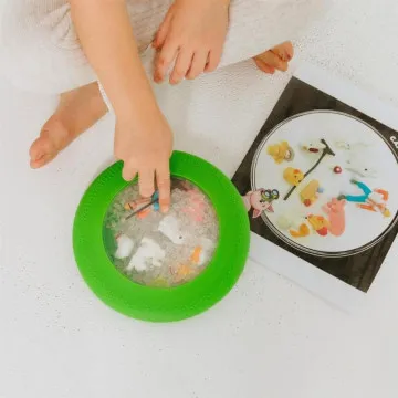 Otrok se igra z Jellystone Peekaboo Kmetija in išče skrite kmetijske figurice