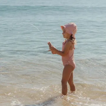 Otrok se igra z Little Dutch vodno pištolo na plaži