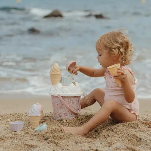 Otrok se igra z Little Dutch Mermaid Ice Cream setom v mivki na plaži