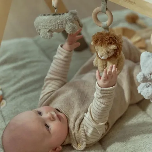 Dojenček leži pod Little Dutch lesenim igralnim lokom Safari Friends